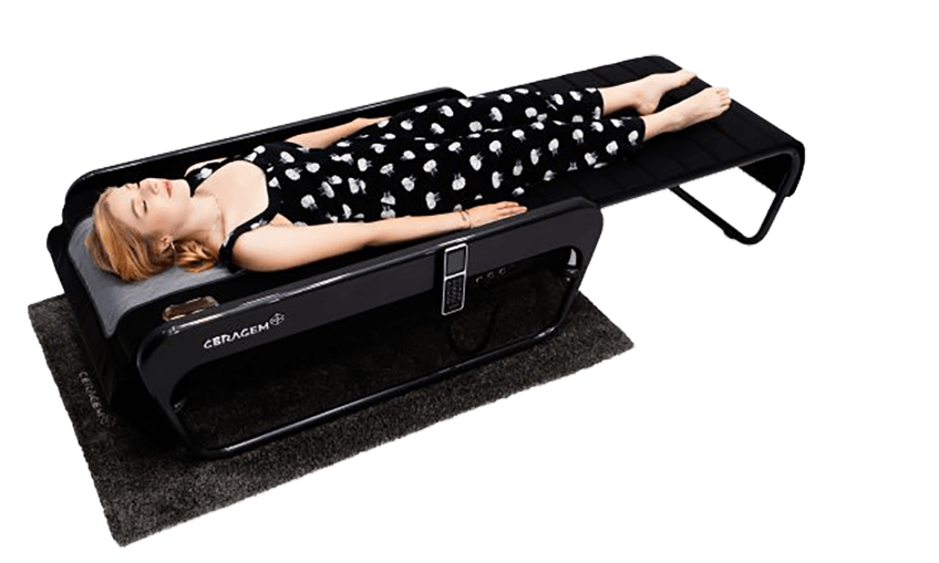 Blonde Frau im schwarzen Kleid erhält Thermalmassage auf Ceragem Master V4 Liege.