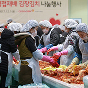 Kimchi Sharing Event: Mehrere Personen mit Mundschutz und Haube verteilen Kimchi. Das Bild zeigt, wie CERAGEM soziale Verantwortung übernimmt