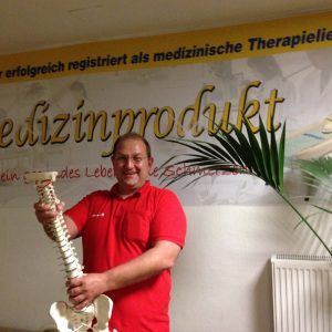 Wilhelm Kirschmann hält eine Wirbelsäule in der Hand.